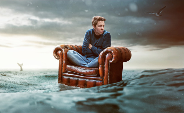 גבר מיואש על ספה בלב ים (אילוסטרציה: Shutterstock)