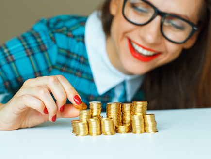 אישה עם ערימות מטבעות (אילוסטרציה: Shutterstock)