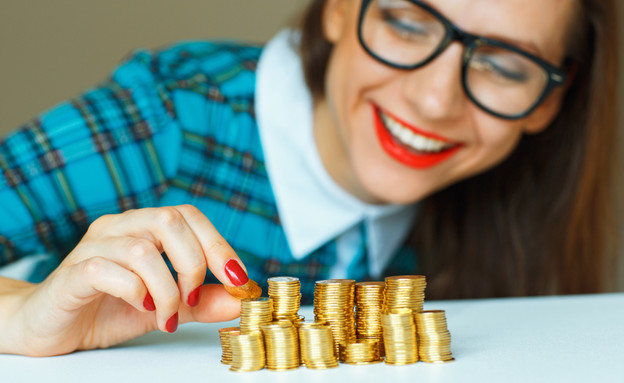 אישה עם ערימות מטבעות (אילוסטרציה: Shutterstock)