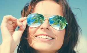 דקלים משתקפים במשקפי שמש של אישה (אילוסטרציה: Shutterstock)