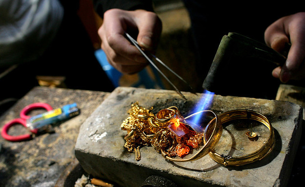 פועל סיני ממיס תכשיטי זהב ישנים (צילום: China Photos, GettyImages IL)