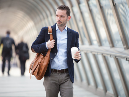 גבר בחליפה הולך עם כוס קפה (אילוסטרציה: Shutterstock)