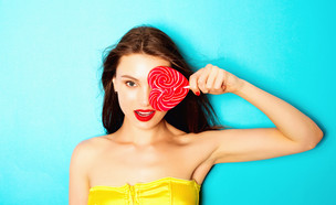 אישה עם סוכרייה על מקל בצורת לב (צילום: Shutterstock, מעריב לנוער)