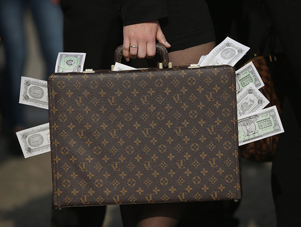 מפגין מחזיק מזוודה מלאה בכסף בהפגנה נגד מסמכי פנמה, ברלין 2016 (צילום: Sean Gallup, GettyImages IL)