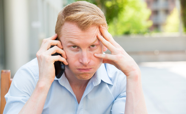 גבר מתוסכל מדבר בטלפון הסלולרי (צילום: Shutterstock)