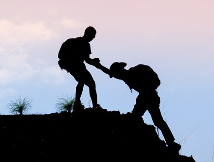 מטייל עוזר לחברו לטפס על הר (צילום: Doidam 10, Shutterstock)