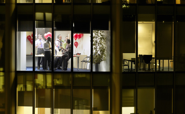 מסיבת משרד נראית דרך חלון בניין משרדים (צילום: sirtravelalot, Shutterstock)