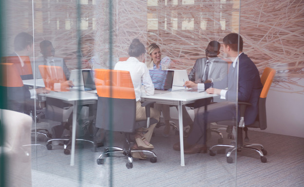 אנשי עסקים יושבים סביב שולחן (צילום: dotshock, Shutterstock)