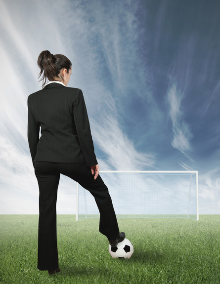 אשת עסקים בועטת בכדורגל (צילום: alphaspirit, Shutterstock)