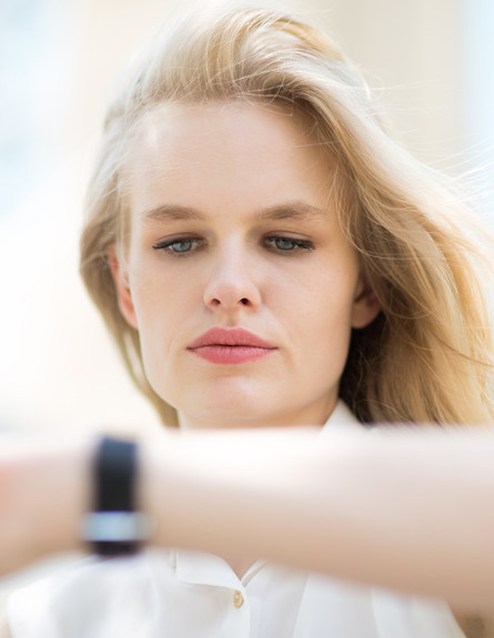 אשת עסקים מסתכלת על שעון יד (צילום: PKpix, Shutterstock)