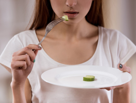 אישה אוכלת מעט (צילום: VGstockstudio, Shutterstock)