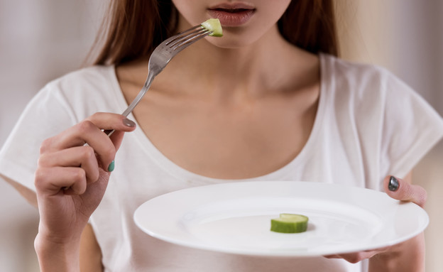 אישה אוכלת מעט (צילום: VGstockstudio, Shutterstock)