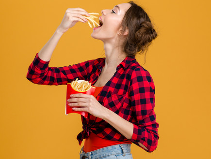אישה אוכלת צ'יפס (צילום: Shutterstock)