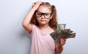 ילדה עם משקפיים מחזיקה שטרות (אילוסטרציה: Shutterstock)