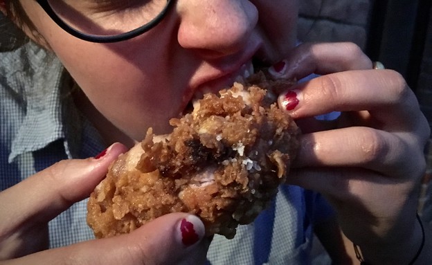 בחורה אוכלת עוף מטוגן  (צילום: מיכל לויט, mako אוכל)