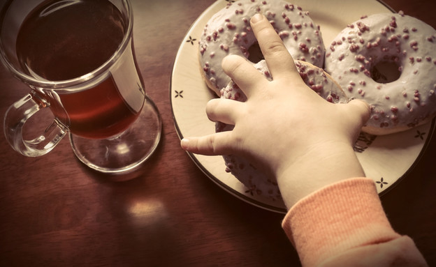 ילדה אוכלת סופגניות (צילום: Shutterstock)