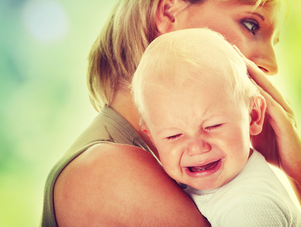אמא מחבקת תינוק בוכה (צילום: Shutterstock)