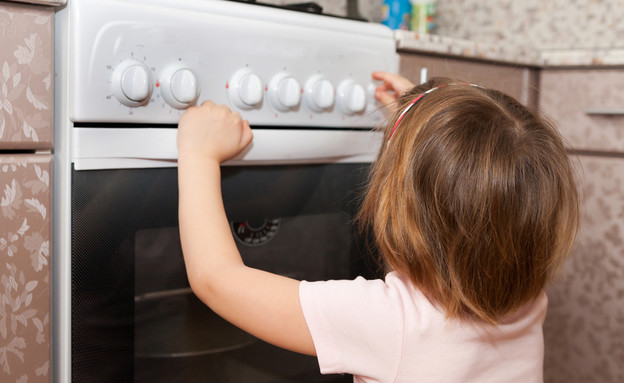 ילדה נוגעת בתנור  (צילום: Shutterstock)
