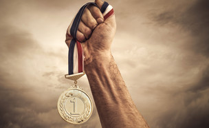 יד מחזיקה מדליית ניצחון (צילום: Shutterstock)