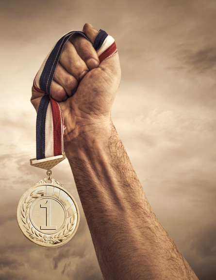 יד מחזיקה מדליית ניצחון (צילום: Shutterstock)