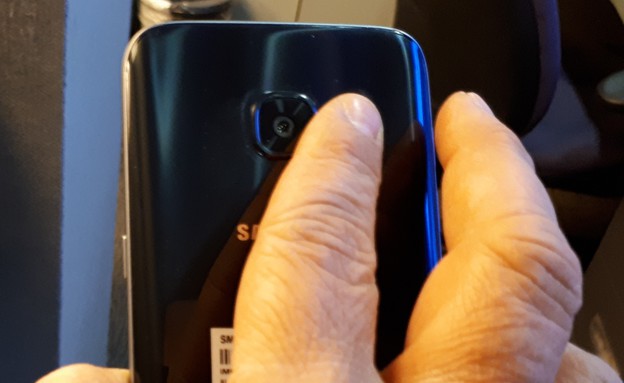 אצבע מונחת על המבזק של מצלמת גלקסי S7 (צילום: יאיר מור, NEXTER)