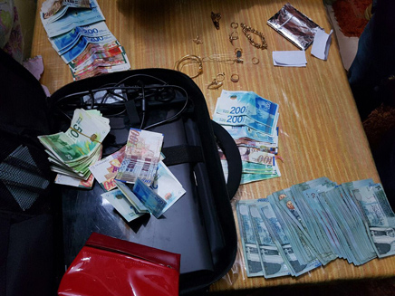 חלק מהכסף שנתפס בפשיטה (צילום: דוברות המשטרה)