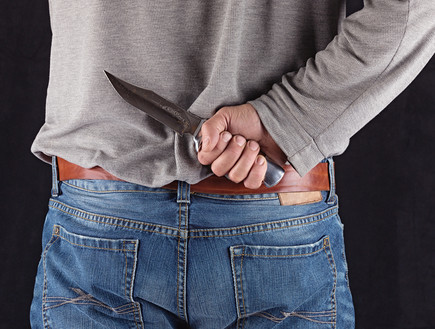 גבר מחזיק סכין מאחורי הגב (אילוסטרציה: Shutterstock)