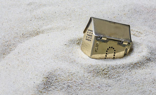 מודל של בית שוקע בחול (אילוסטרציה: Shutterstock)