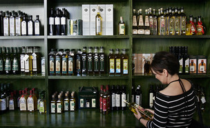 לקוחה בוחרת שמן זית בחנות במרכז מדריד (צילום: ap)