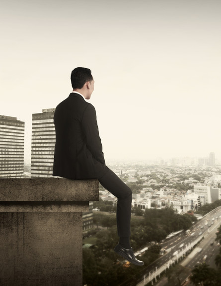 איש עסקים יושב על קצה גג (אילוסטרציה: Shutterstock)