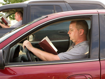 גבר קורא ספר במכונית (אילוסטרציה: Shutterstock)