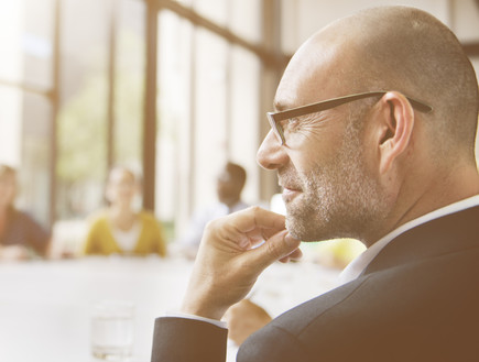 איש עסקים מביט לחלון בפגישה (אילוסטרציה: Shutterstock)