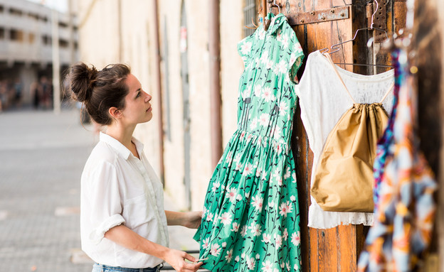 אישה בוחרת בגדים בחנות ביפו (צילום: Shutterstock)