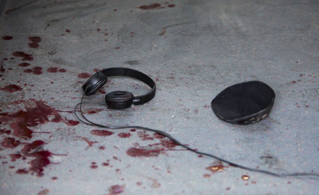 אוזניות וכיפה וכתמי דם בתחנת אוטובוס לאחר פיגוע דקירה בתל אביב (צילום: עודד בלילטי, ap)