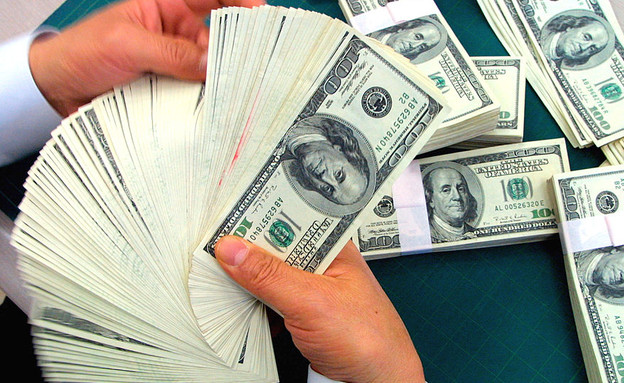 בנקאי סופר שטרות של דולרים (צילום: Chung Sung-Jun, GettyImages IL)