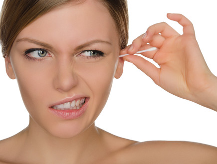 אישה מנקה אוזניים (צילום: Shutterstock)
