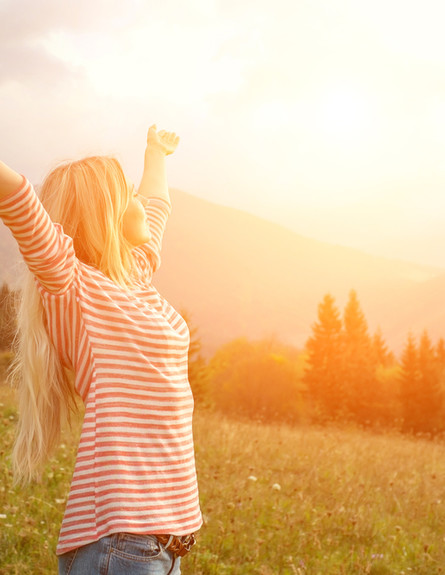 אישה שמחה בשקיעה (צילום: Shutterstock)
