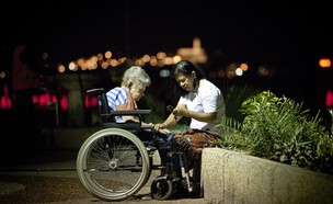 מטפלת פיליפינית עם קשישה בטיילת בתל אביב (צילום: משה שי לפלאש 90)