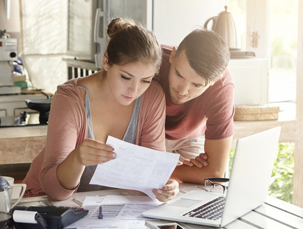 זוג צעיר בודק ניירת (אילוסטרציה: Shutterstock)