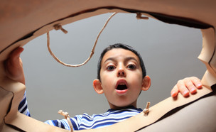 ילד פותח מתנה (צילום: Shutterstock)
