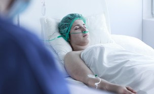 אישה במיטת בית חולים (צילום: Photographee.eu, Shutterstock)