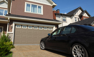 מכונית עומדת לפני דלת חניה ביתית (צילום: ShutterStock)