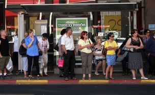 נוסעים ממתינים בתחנה לאוטובוס בתל אביב (צילום: דניאל בר און, TheMarker)
