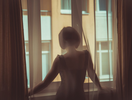 אישה בחלון (צילום: Liukov, Shutterstock)