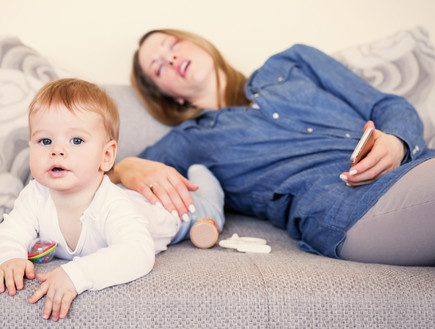 אמא טרייה ישנה ליד התינוק  (צילום: Kaspars Grinvalds, Shutterstock)