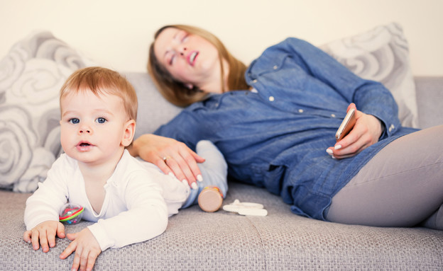 אמא טרייה ישנה ליד התינוק  (צילום: Kaspars Grinvalds, Shutterstock)