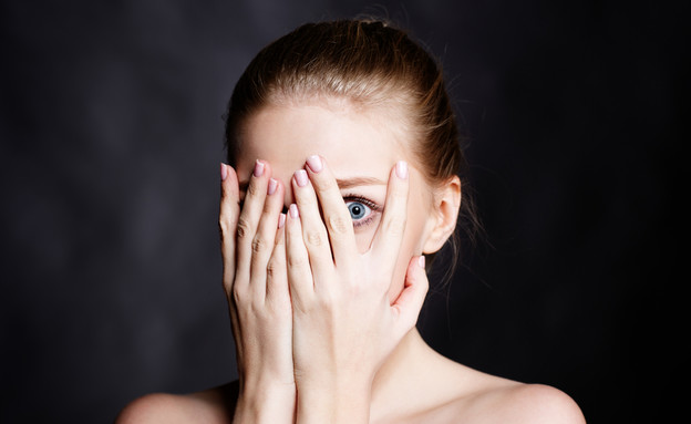 אישה מפחדת מציצה דרך היד (צילום: Ipatov, Shutterstock)