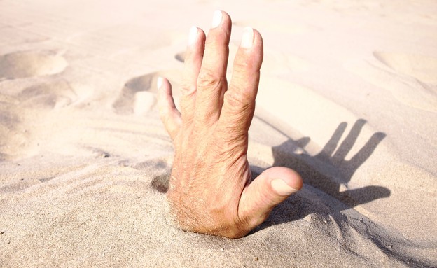יד בחול (צילום: Mike Richter, Shutterstock)