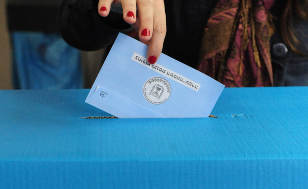 יד מכניסה מעטפה לקלפי בבחירות (צילום: ChameleonsEye, ShutterStock)