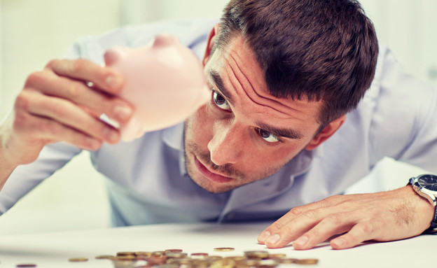 גבר מחפש מטבעות בקופת חיסכון (אילוסטרציה: Syda Productions, Shutterstock)